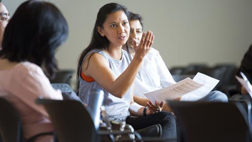 A faculty member in a group conversation with others